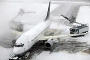 عملیات برف روبی از روی بال هواپیما/ عکس