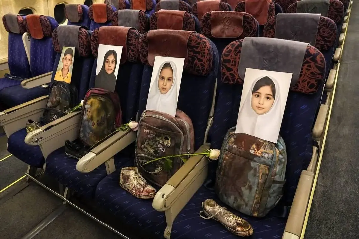 تصویری از عراقچی در مقابل وسایل به‌جا مانده از شهدای دانش‌آموز میناب 