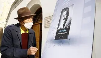 علی نصیریان در حال امضای پوستر کتاب «جمشید مشایخی»