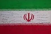 دست‌نوشته نخبگان و مدال‌آوران علمی و ورزشی روی پرچم ایران/ عکس